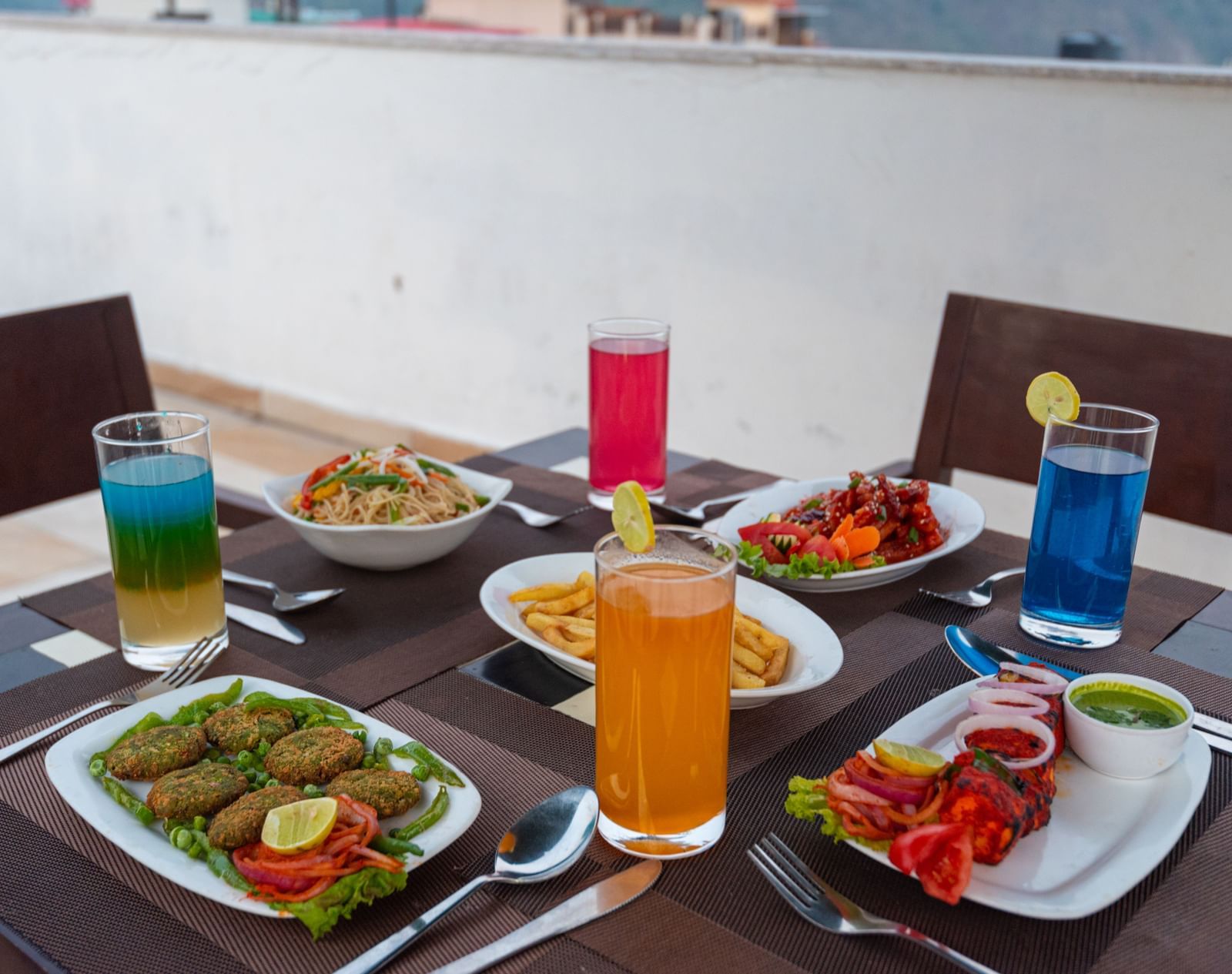 Side view of a beautifully set table with a variety of starters and refreshing beverages at DLS The Classio.
